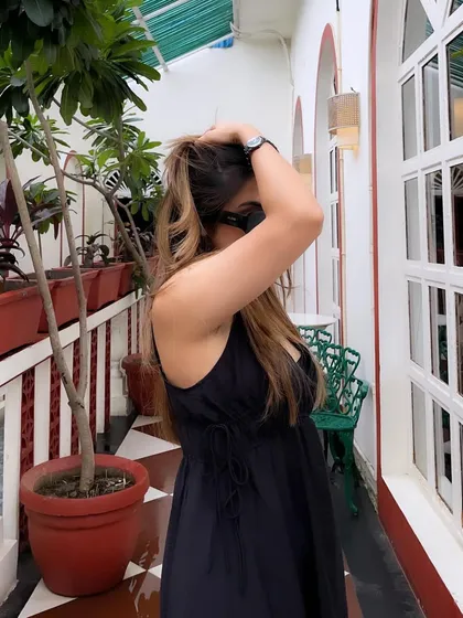 A candid moment adjusting my hair in the black maxi dress.