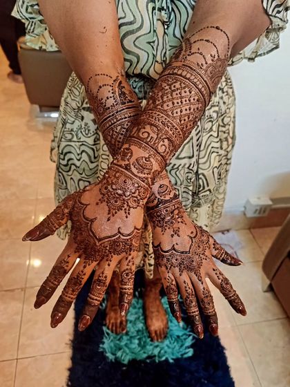 The back of bride Pragna's hands, showing how the intricate patterns continue from the front for a complete and stunning bridal look.