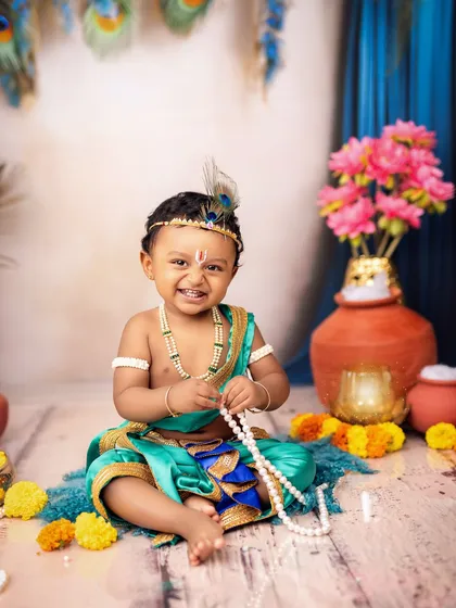 We celebrate culture and tradition with our unique themed shoots. This joyful portrait of a little one as Kanha, with his mischievous grin, is a perfect example of our custom Janmashtami photography sessions, complete with authentic costumes and vibrant props.