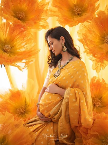 Bathed in golden light and surrounded by vibrant marigold flowers, this portrait in a yellow saree is a celebration of life, warmth, and radiant joy.