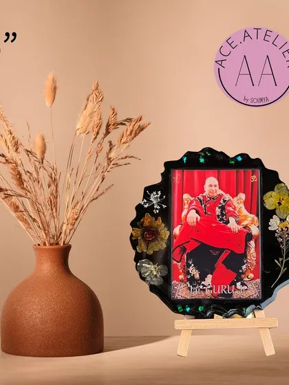 A 6-inch Guruji photo frame in black resin, adorned with a variety of colorful preserved flowers.