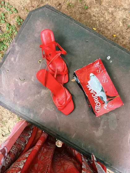 The not-so-glamorous side of a shoot. Red heels and a box of tissues on a dusty surface, a real moment between takes.