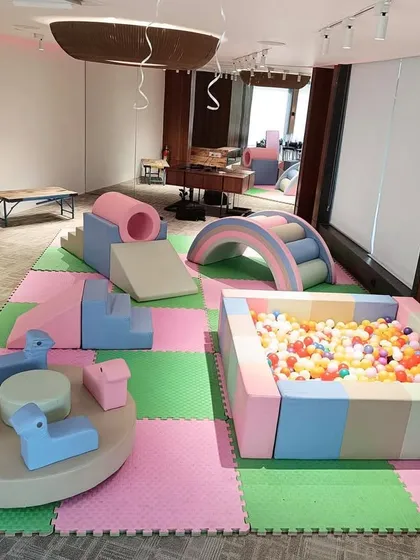 Our Pastel Soft Play Area offers a gentle and modern aesthetic for any party. This setup includes a soft-walled ball pit, foam climbers and slides, a cushioned rainbow arch, and a manual carousel, all laid out on safe, interlocking floor mats.