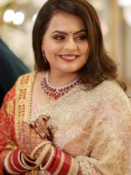A candid shot of the bride at her reception. The smoky eyes and bold lip color look beautiful in the warm lighting of the event, showcasing the makeup's versatility.