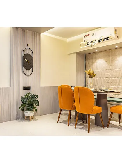 A compact dining area that doesn't compromise on style. The vibrant orange chairs add a pop of energy, while the bench seating is a practical, space-saving solution.