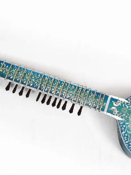 The full neck of the blue rock sitar, showing the consistent and detailed inlay work along its entire length.