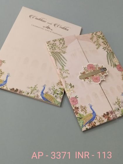This vertical gate-fold invitation features peacocks amidst a delicate floral border. The design is traditional yet fresh, with a simple nameplate to hold it closed.