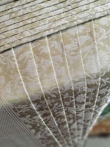 A close-up of a pre-pleated Banarasi saree, showcasing the intricate weave and the perfect pleats.