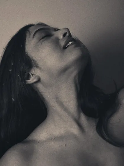 This pose, captured in black and white, highlights the elegant lines of the neck and jaw. It's a study in form and vulnerability.