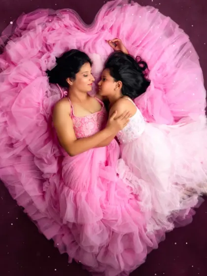 A heartwarming mother-daughter portrait. Our pink ruffled gown creates a beautiful heart shape, symbolizing the love that connects them.