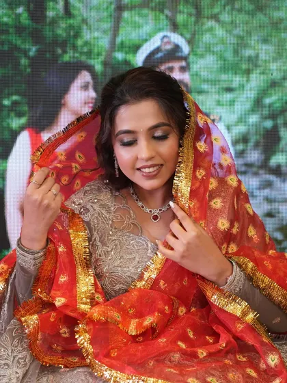A traditional moment during the engagement ceremony, with the bride holding a beautiful red dupatta.