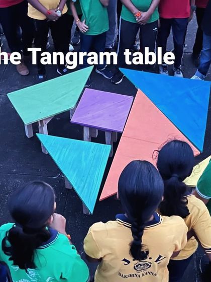 Students gather around their completed Tangram Table. The project is a tangible representation of their collective effort and learning.