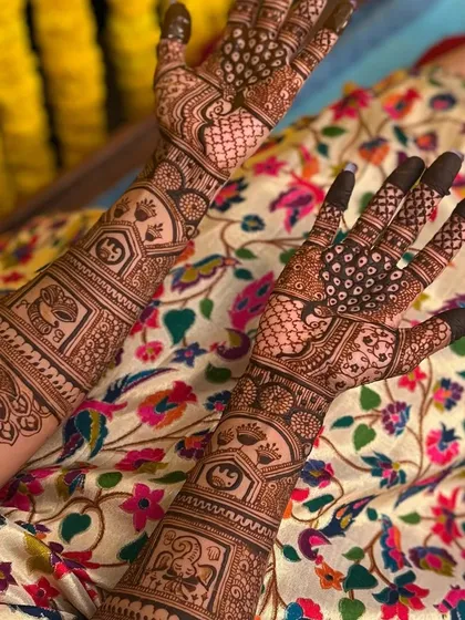 A close-up of Sahana's palm designs, featuring peacocks and personalized initials.