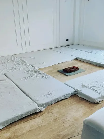 For a traditional Hawan or Pooja, I provide simple and clean floor seating arrangements. This shows mattresses with white covers placed around the central hawan kund area.