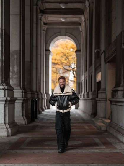 A street style portrait of Christian Bendek in a New York City colonnade. The natural framing and soft light create a classic, cinematic feel.
