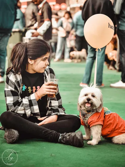 A girl and her dog, sharing a quiet moment together. The little balloon that says "henlo" adds a touch of whimsy. These are the slice of life stories I love to tell through my pet event photography.