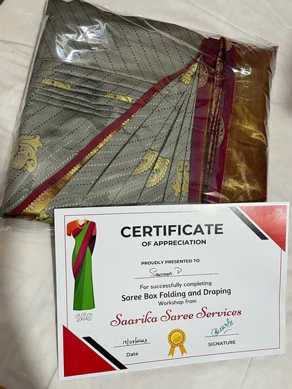 A grey silk saree with a maroon border, neatly folded and packed after an offline workshop.