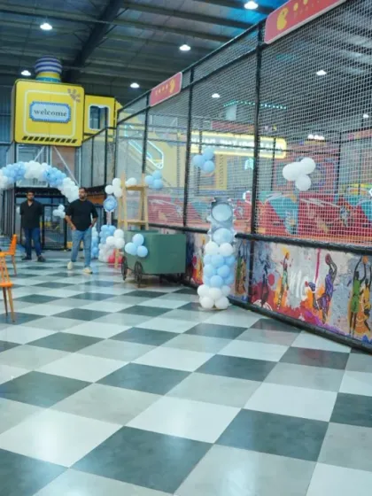 The race car theme continues with tire and helmet-shaped balloon decorations, leading guests into the main party and play area.