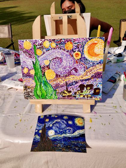 The amazing result! A student proudly displays her version of "Starry Night" next to the reference photo at our outdoor workshop.
