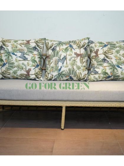 A closer look at our rattan-style sofa with custom jungle-themed cushions. The frame's gentle curves and the soft grey seat provide a comfortable and stylish foundation for your outdoor decor.