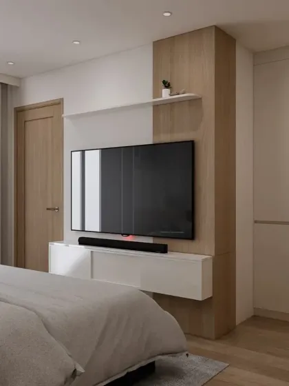 This view shows the TV and storage wall in the minimalist bedroom. The combination of white and wood finishes keeps the space feeling bright and uncluttered.