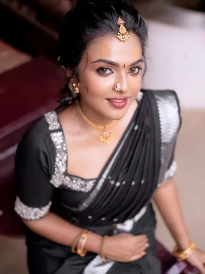 A high-angle shot of the model in a black saree. The makeup is elegant and timeless, perfect for any special occasion.