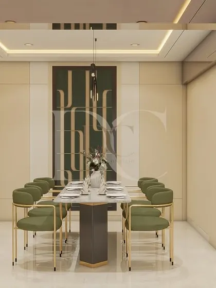 This dining space is all about modern elegance. We paired green upholstered chairs with a sleek marble-top table and added a custom-built crockery unit with fluted glass and internal lighting for a high-end finish.