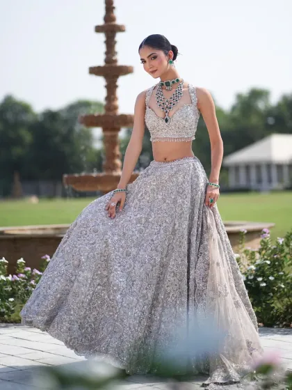 A regal pose in front of a fountain. The styling of this silver lehenga is all about creating a look of timeless elegance and modern luxury.
