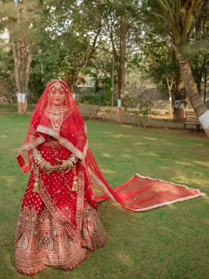 A stunning portrait of the bride with the long trail of her dupatta spread out on the grass. We love creating these dramatic, elegant shots.