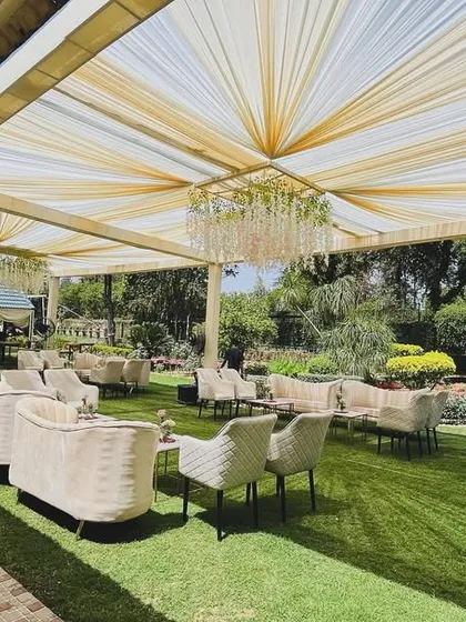 We transform open spaces into elegant venues for corporate gatherings. This daytime event at a Chhatarpur farmhouse features a sophisticated lounge setup under a draped canopy with crystal chandeliers, perfect for executive retreats or client appreciation parties.