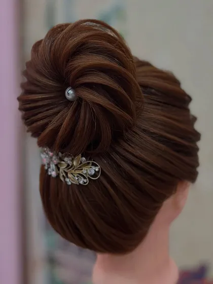 Another fantastic creation by a student. This intricate bun with delicate twists and accessories shows great skill and attention to detail.