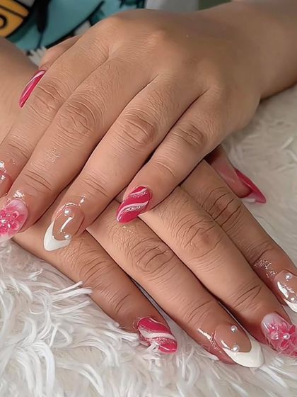 A creative set combining a white French tip with pink marble and 3D floral accents. This shows how to mix multiple styles into one cohesive look.