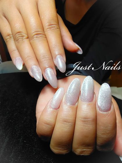 A simple yet stunning set of long, almond-shaped extensions with a shimmering, pearly white glitter polish.