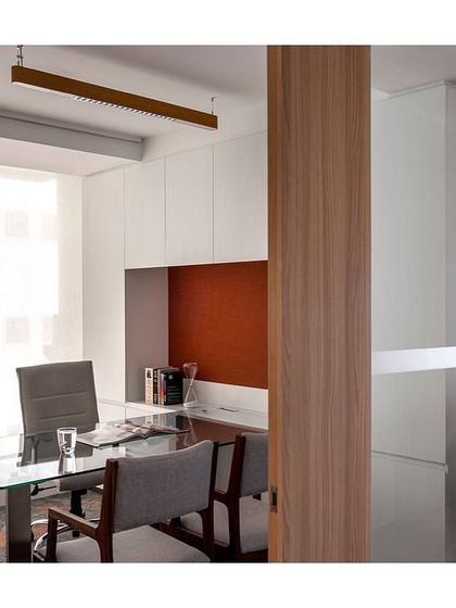 A view into a cabin in 'The Office with A View'. The design uses a glass wall to maintain a sense of openness while providing acoustic privacy. The interior features a clean, functional layout with ample storage.