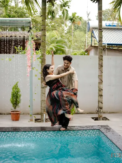 A playful splash and a joyful dance by the pool. This candid moment captures the fun and spontaneity of the couple's relationship.