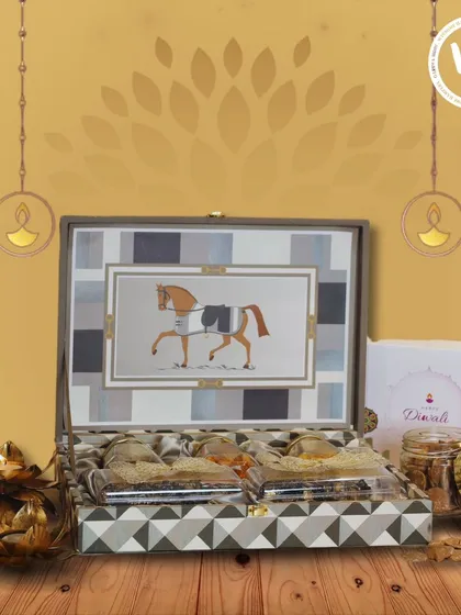 A uniquely designed gift box featuring an elegant horse motif, perfect for a distinguished Diwali present. The box opens to reveal a curated selection of Indian sweets and savories, blending traditional tastes with artistic packaging.