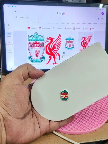 The process of creating a tiny, edible Liverpool logo by hand. For personalized cakes, getting these small but important details just right is everything.