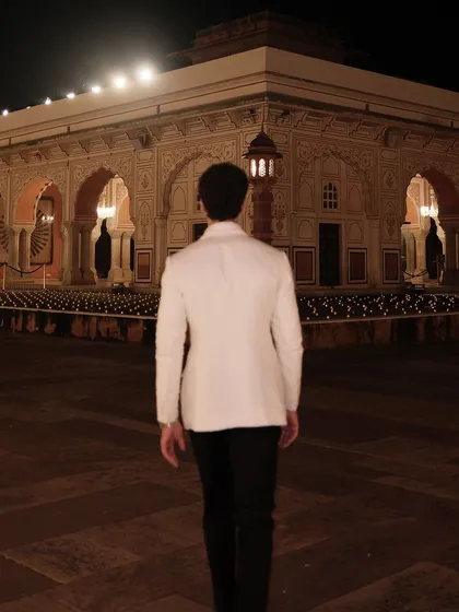 Our client walking through the City Palace grounds. The back of the white linen jacket shows the clean lines and perfect fit we achieve.