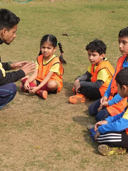 A coach talking to young players. We are committed to nurturing talent and building character for the next generation of athletes.