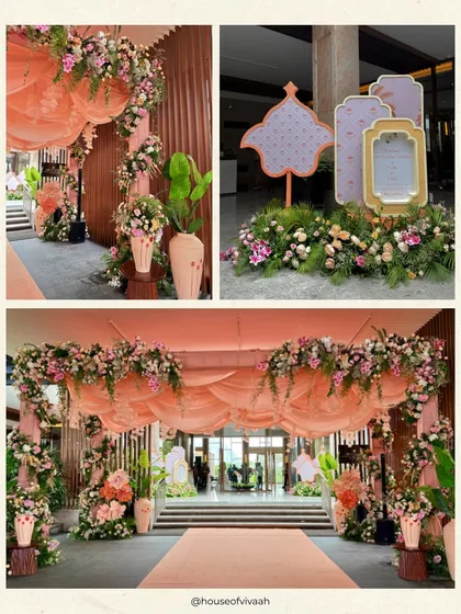 The grand entrance to the Welcome Lunch, with dramatic peach-toned drapes and lush floral arches creating a warm and inviting welcome for guests.