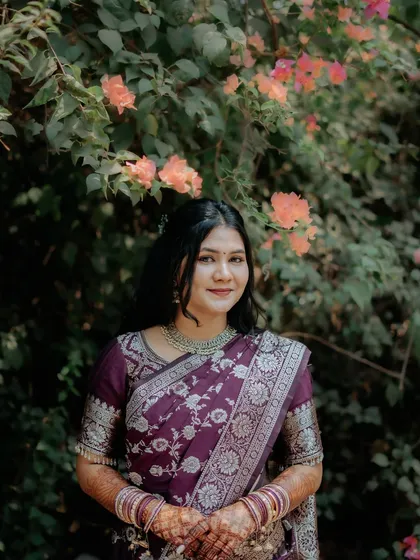 A beautiful portrait of the bride-to-be during her engagement shoot, standing before a wall of flowers.