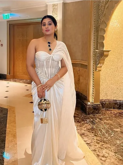 Ivory dreams sculpted to perfection. An embellished corset is paired with a draped skirt and a statement structured drape, where elegance meets edge.