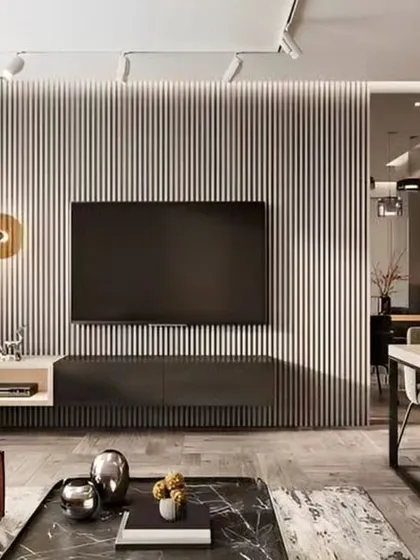 A contemporary open-plan living and dining space. The living area is defined by a grey fluted wall with a minimalist TV console, while the adjacent dining area features elegant modern furniture.