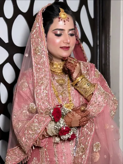 A beautiful portrait of my client in a Pakistani-style pink suit. The HD makeup gives her a glowing, flawless finish, complemented by a floral braid.