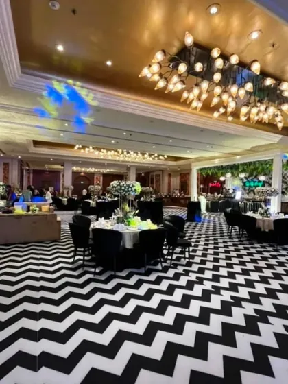 An indoor engagement party with a bold and modern aesthetic. The striking black and white chevron floor contrasts beautifully with the elegant table settings and grand lighting fixtures, showing how I transform indoor venues.