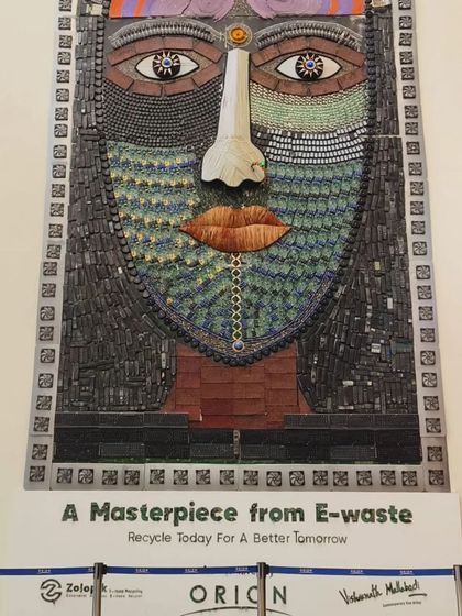 A poster displayed at Orion Mall, presenting the mural as "A Masterpiece from E-waste." This simple but powerful statement, placed next to the artwork, reinforces the message of recycling for a better tomorrow.