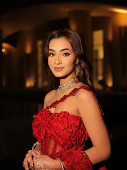 A confident portrait in the red couture gown. The intricate floral details on the blouse and the dramatic silhouette make this a true showstopper, styled for maximum impact.