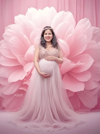 This portrait combines a delicate pink gown with an oversized flower backdrop. The soft, tonal pinks create a very gentle and feminine image, perfect for celebrating your pregnancy.