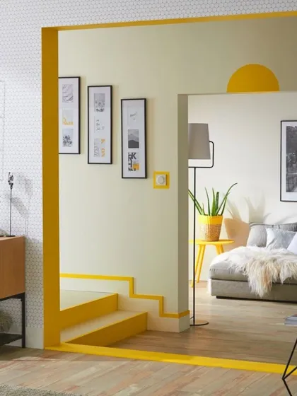 We used a simple yet clever pop of bright yellow to outline this entryway and staircase. This creative use of paint defines the architecture of the space, guiding the eye and adding a playful, modern touch without any structural changes.