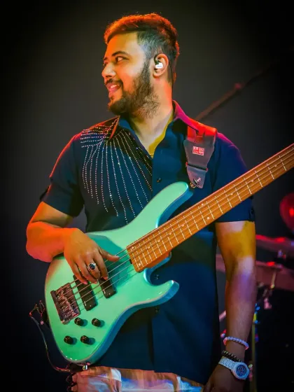 Our bassist smiling during a performance at the ITC Royal Bengal. We love what we do, and it shows.